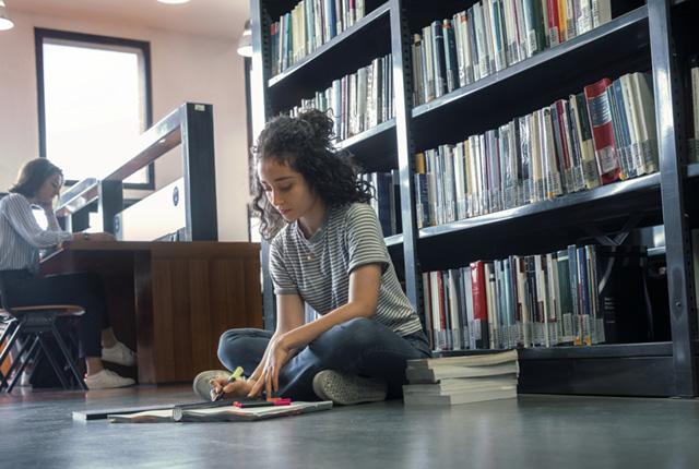 studentessa che legge una guida