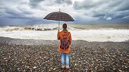 Ragazza con ombrello guarda il mare